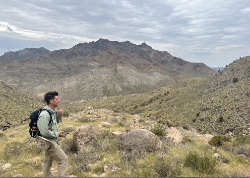 Researcher in foreground of Mojave desert mountain setting